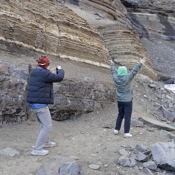People enjoying Hengifoss waterfall cascading 118 meters down