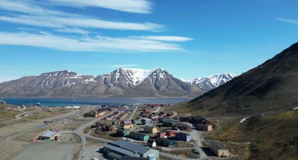 The colourful houses of Longyearbyen below snow-covered mountains, Svalbard, Norway
