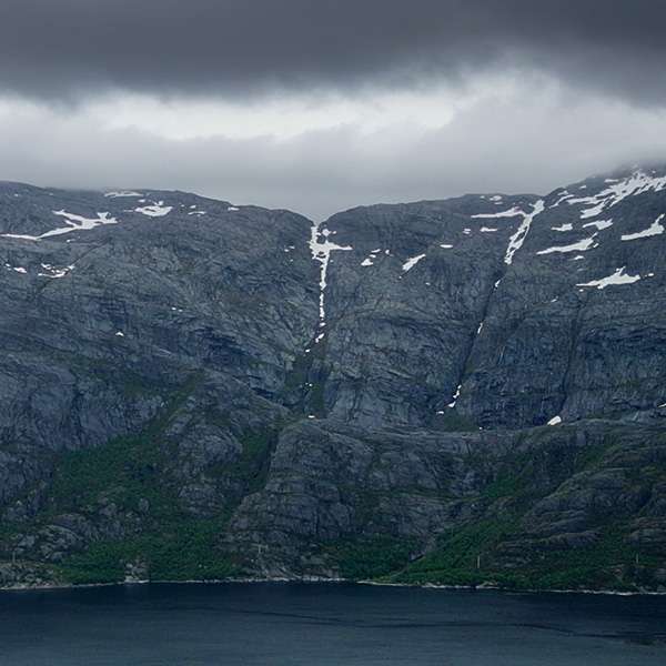 Thin waterfall running down a steep mountain wall near Sandnessjøen, Helgeland, Norway