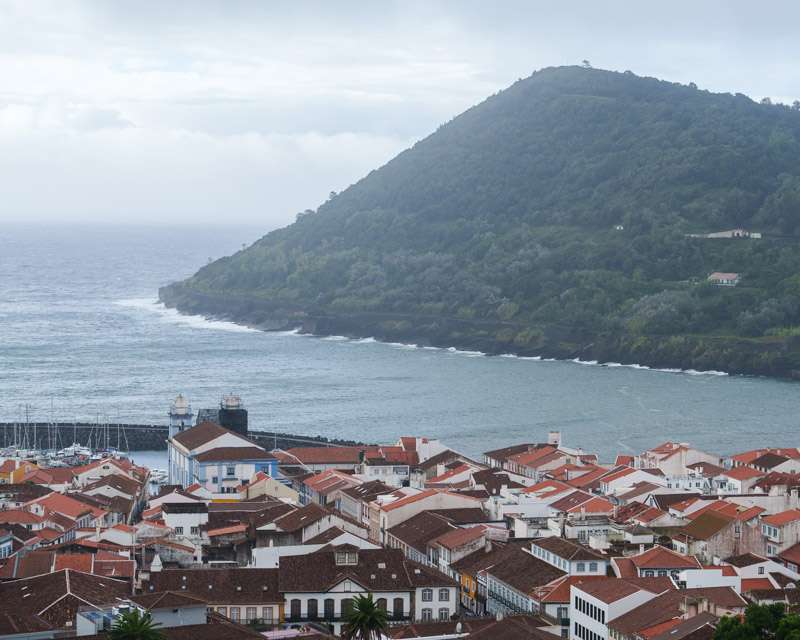 Red roofs of Angra with the harbour breakwater and the green dome of Monte Brasil
