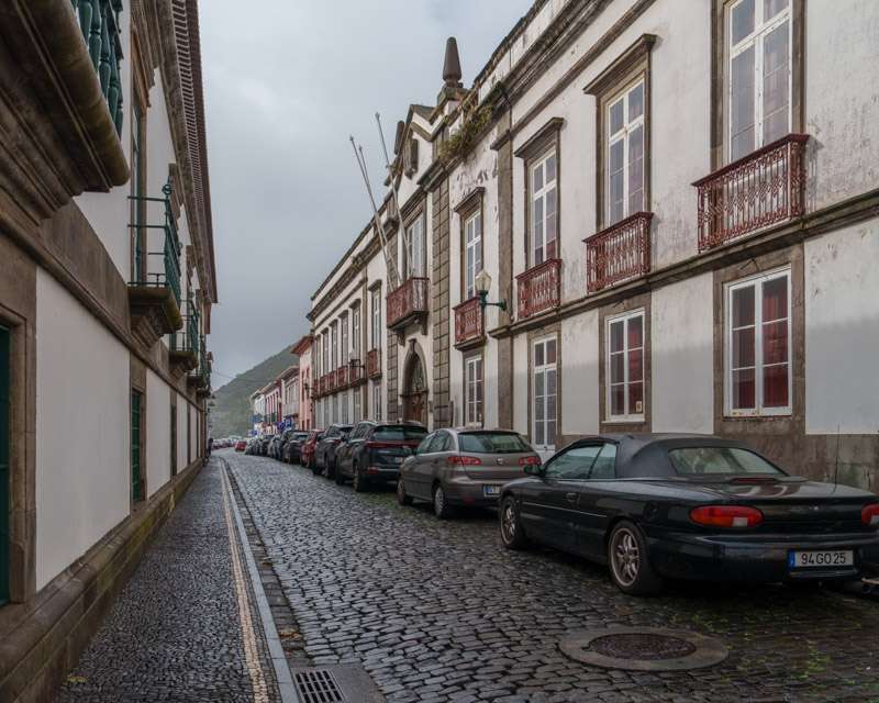 Cobbled street of tall eighteenth-century houses with iron balconies in Angra
