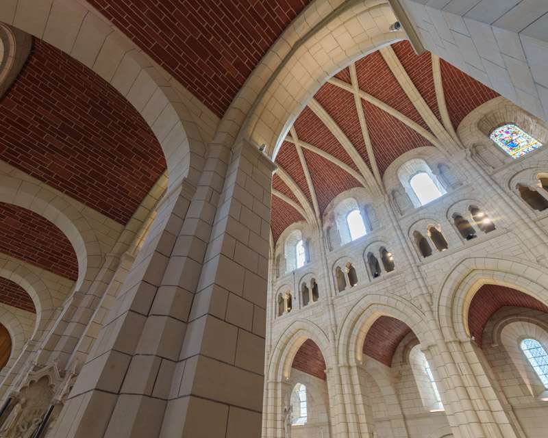 Red and white banded arches and vaulting in the roof of Buckfast Abbey church