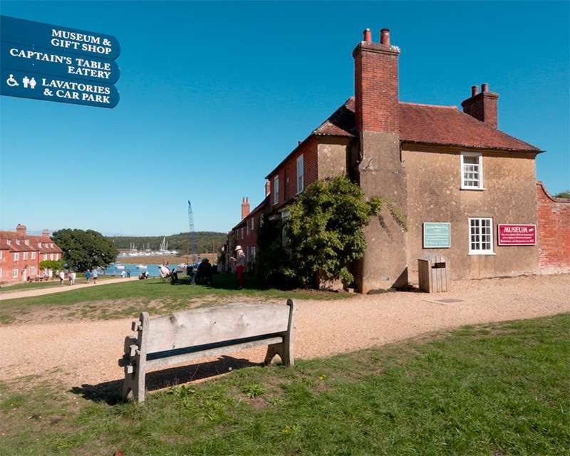 The wide main street of Buckler's Hard between two rows of Georgian brick cottages