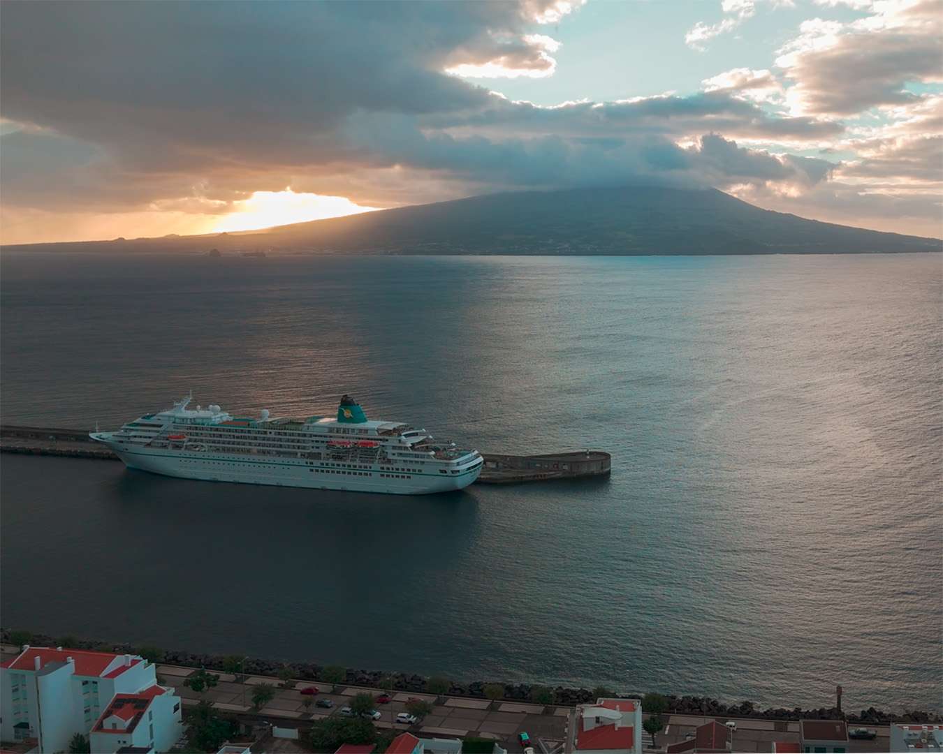 MS Amadea at the quay in Horta at sunset with the cone of Pico across the channel