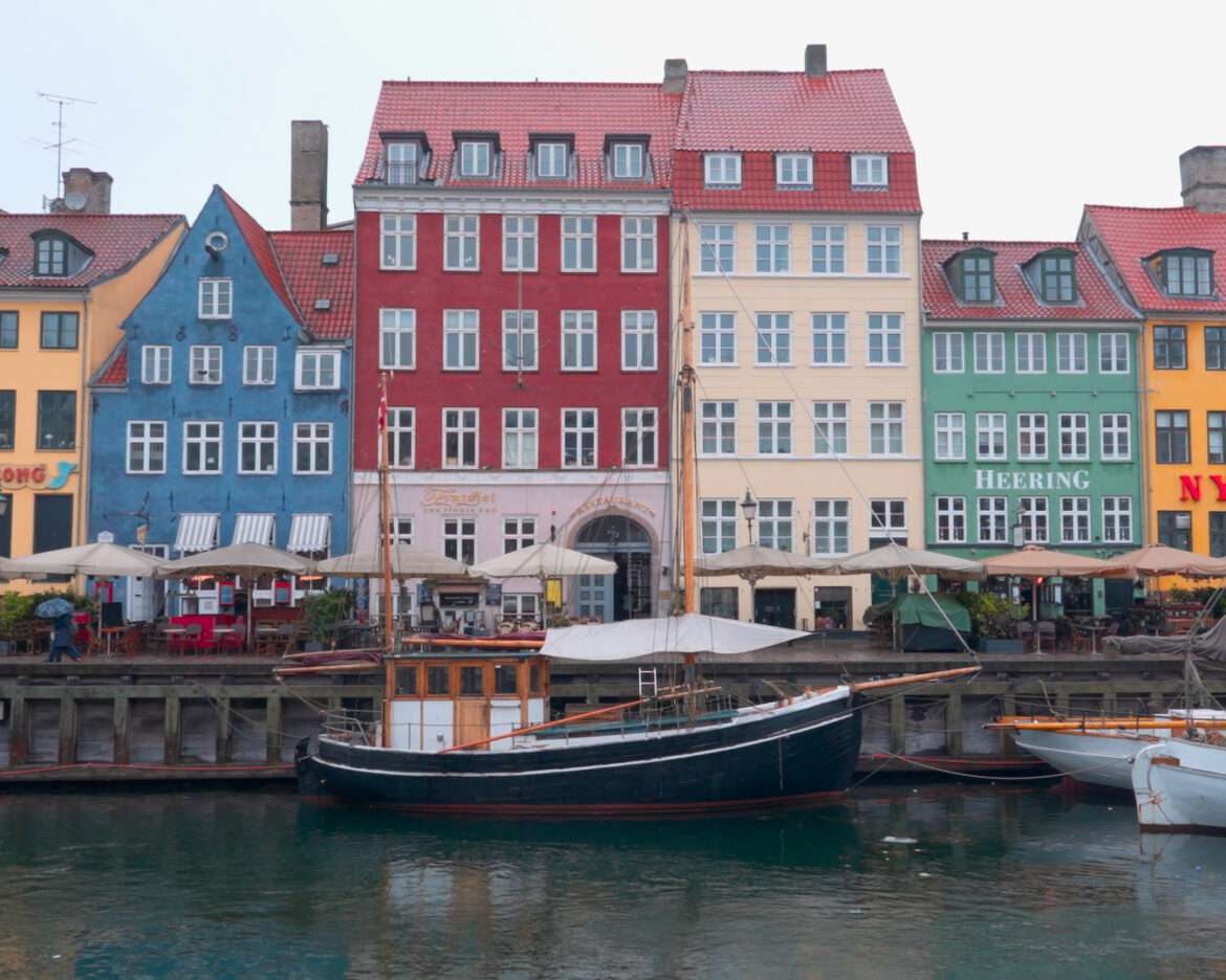 Colourful gabled houses and a wooden boat on the Nyhavn canal in Copenhagen