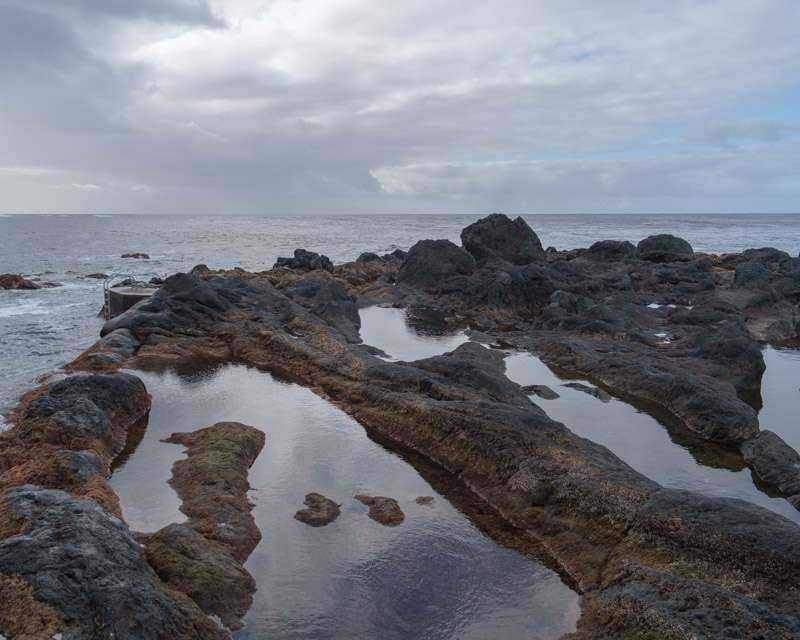 Still tidal pools among black lava rocks at Porto do Comprido, Faial, Azores