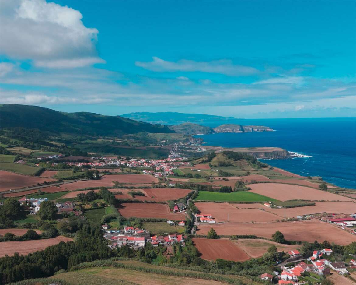 View from the Miradouro de Santa Iria over fields, a village and the north coast of São Miguel