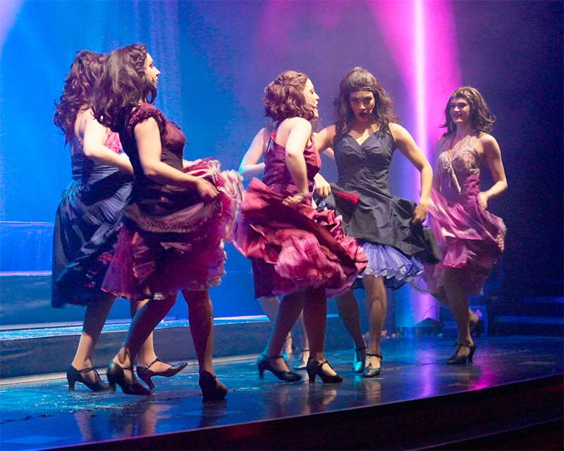 Dancers in period dresses on stage during the evening show on board