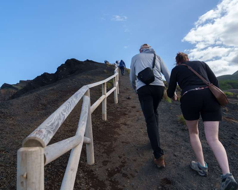 Visitors climbing the fenced ash path towards the Capelinhos crater rim, Faial, Azores