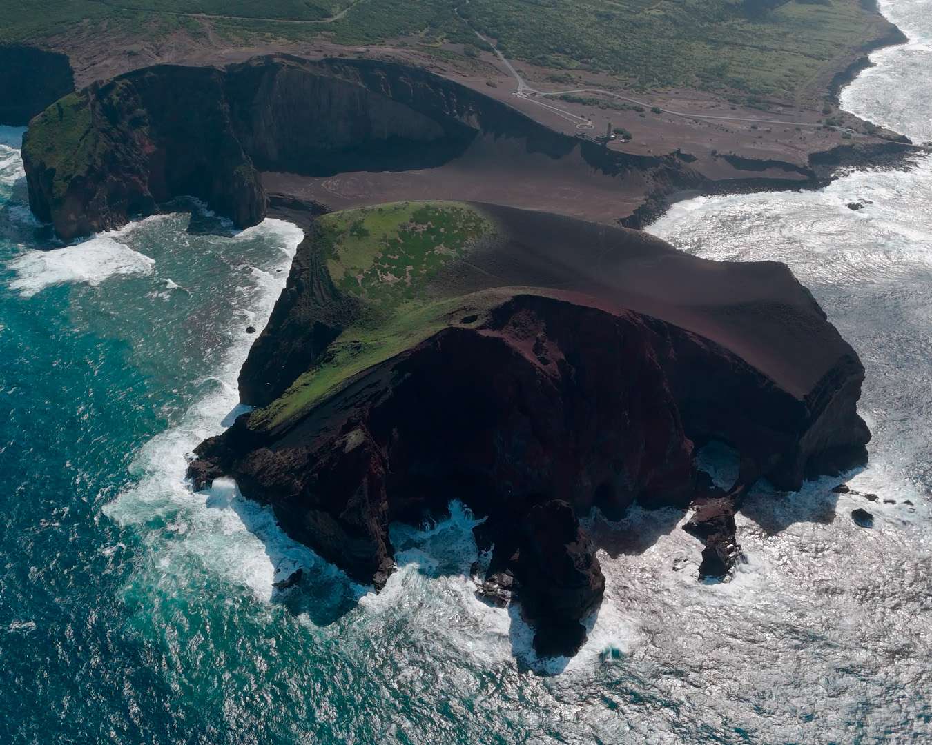 The Capelinhos peninsula from the air, black ash against green fields and Atlantic surf
