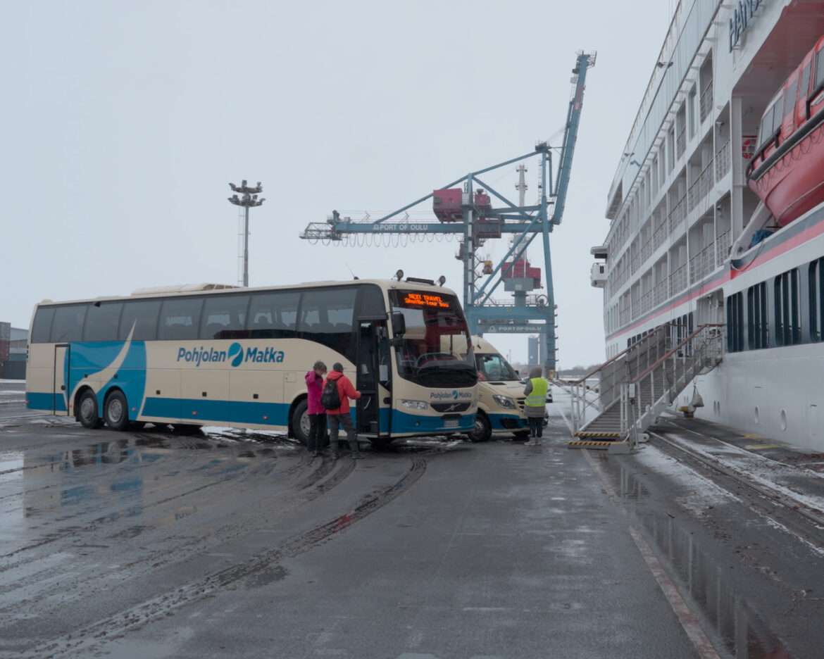Expedition ship HANSEATIC nature at the cargo quay in Oulu with a coach waiting alongside