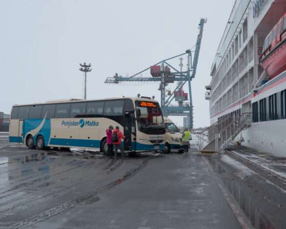 Expedition ship HANSEATIC nature at the cargo quay in Oulu with a coach waiting alongside