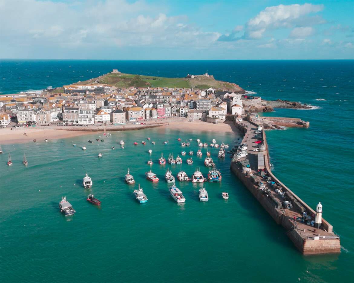 Aerial view of St Ives harbour with the pier, the lighthouse and moored boats, Cornwall