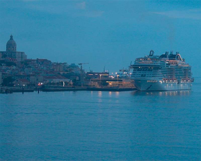 Lissabons Uferfront im ersten Licht mit einem Kreuzfahrtschiff unterhalb der Altstadt