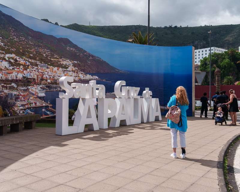 Large SANTA CRUZ LA PALMA letters on the waterfront promenade in front of a mural of the island