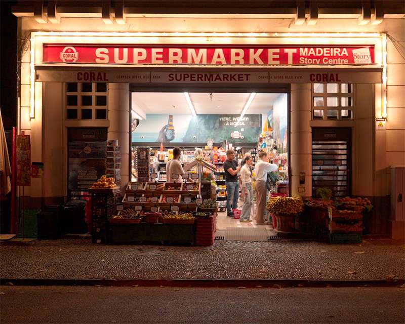 Lit entrance of the supermarket at the Madeira Story Centre in Funchal old town in the evening