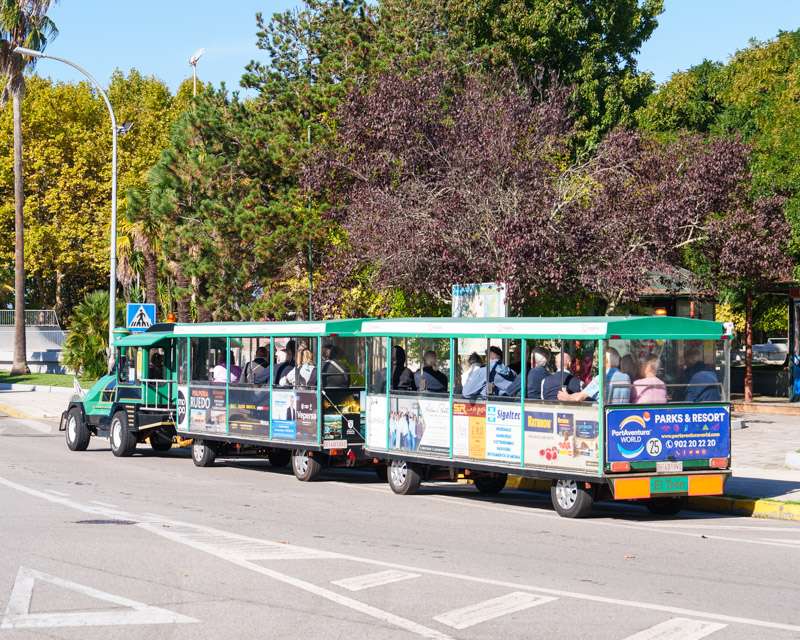 Green and white tourist road train carrying cruise passengers from the port into Vilagarcía de Arousa
