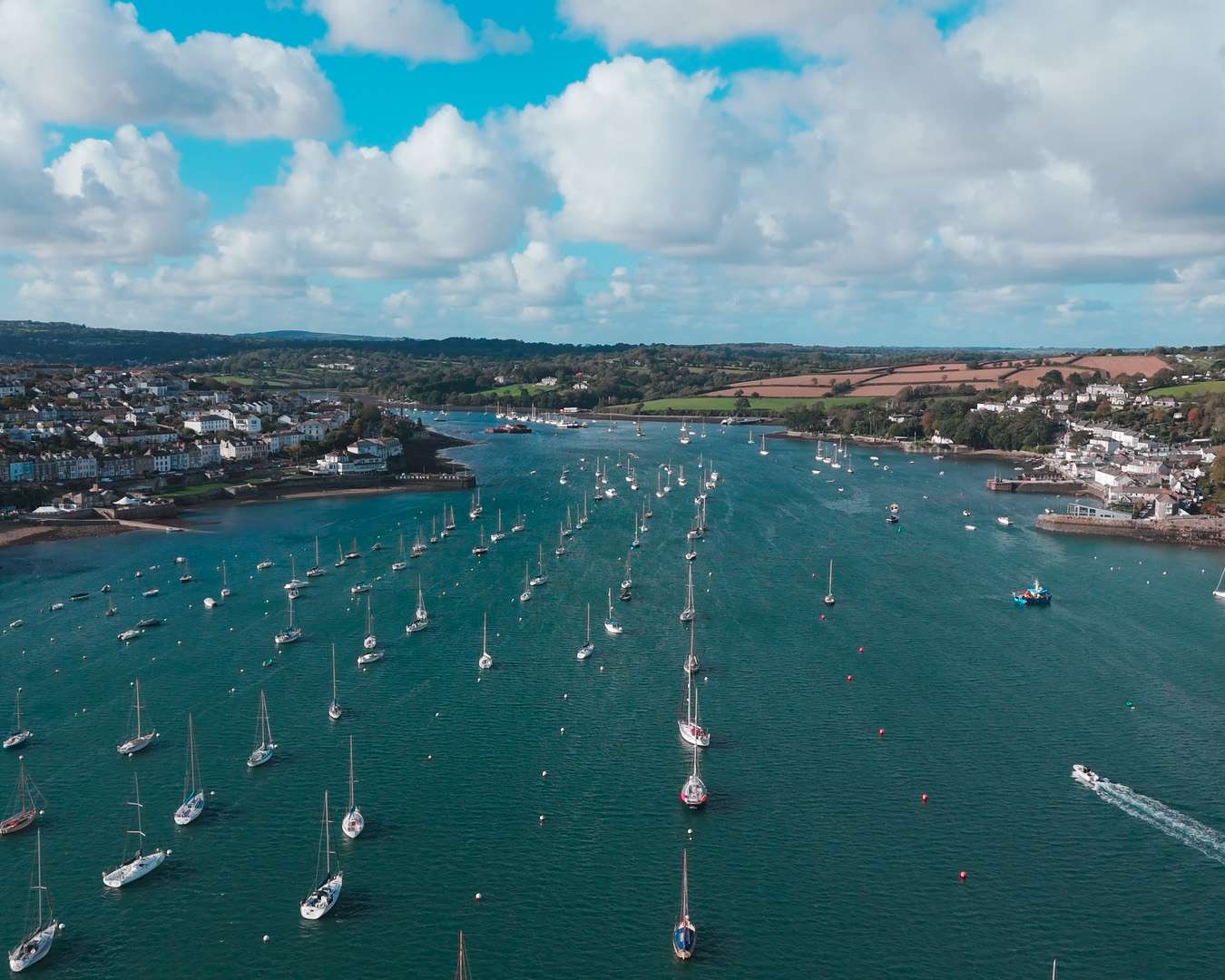 Aerial view of Falmouth harbour with moored yachts, the Penryn river and the Cornish coast behind