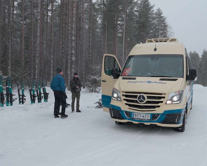 Minibus and snowshoes at the Pilpasuo car park in the snow-covered pine forest near Oulu