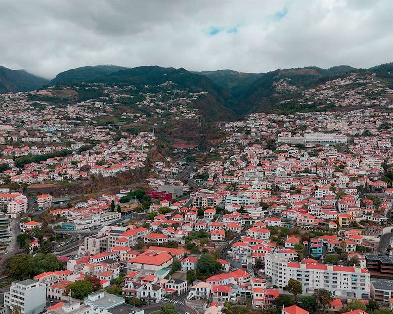 Funchal seen from above, red roofs climbing the slope towards the mountains