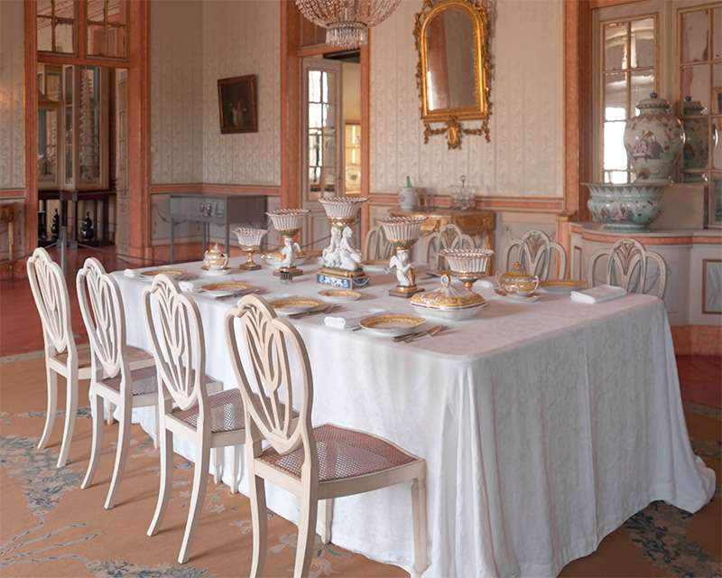 Der gedeckte Tisch in Queluz mit weißem Leinen und Porzellan in einem verspiegelten Raum