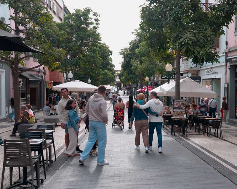 Pedestrian street in central Funchal with black and white Portuguese pavement and cafe tables