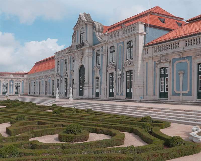 Buchsparterre im Garten von Queluz mit dem langen Palastflügel dahinter