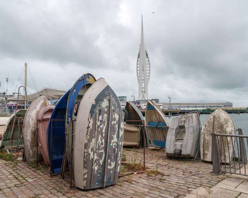 Upturned dinghies stacked on the quay with the Spinnaker Tower behind, Portsmouth