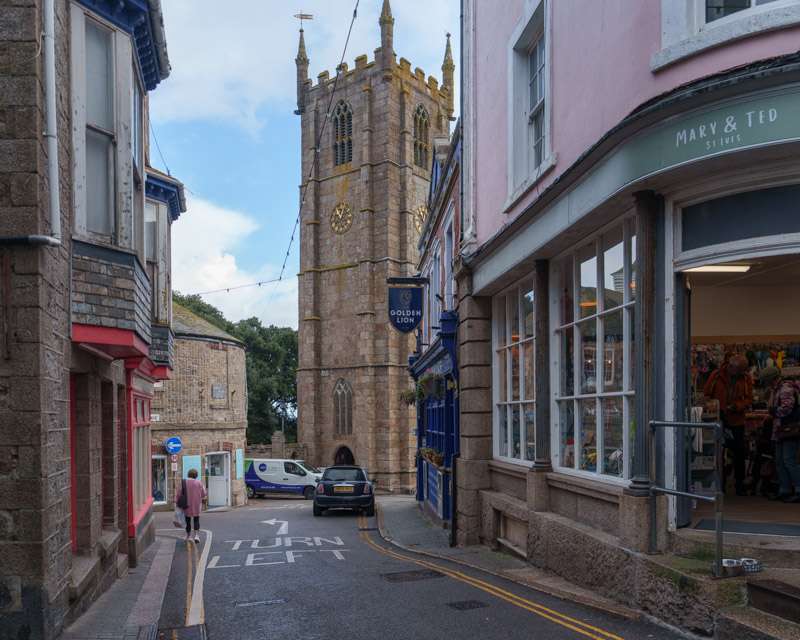 Shops and the granite tower of St Ia parish church in the centre of St Ives
