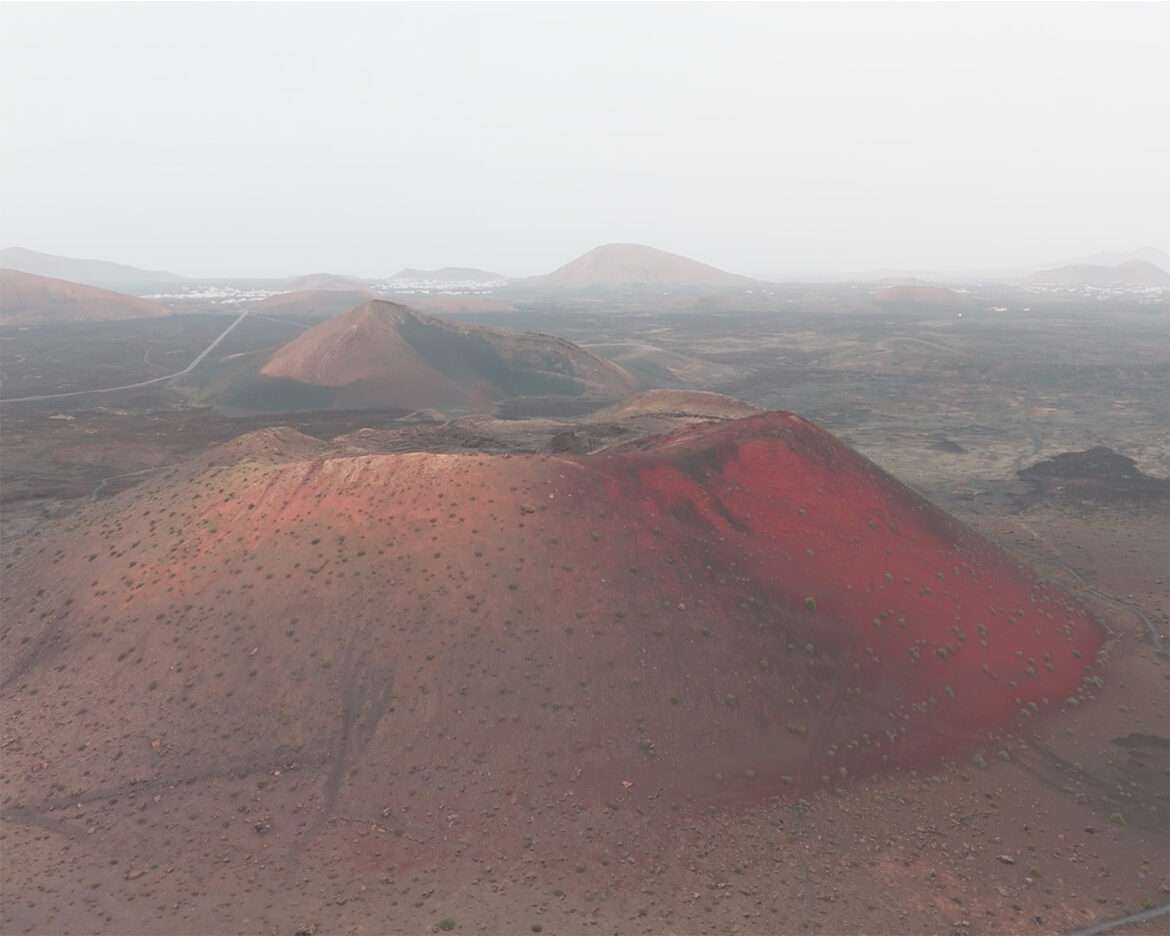 Montaña Colorada from the air, a red volcanic cone in the black lava field of Lanzarote