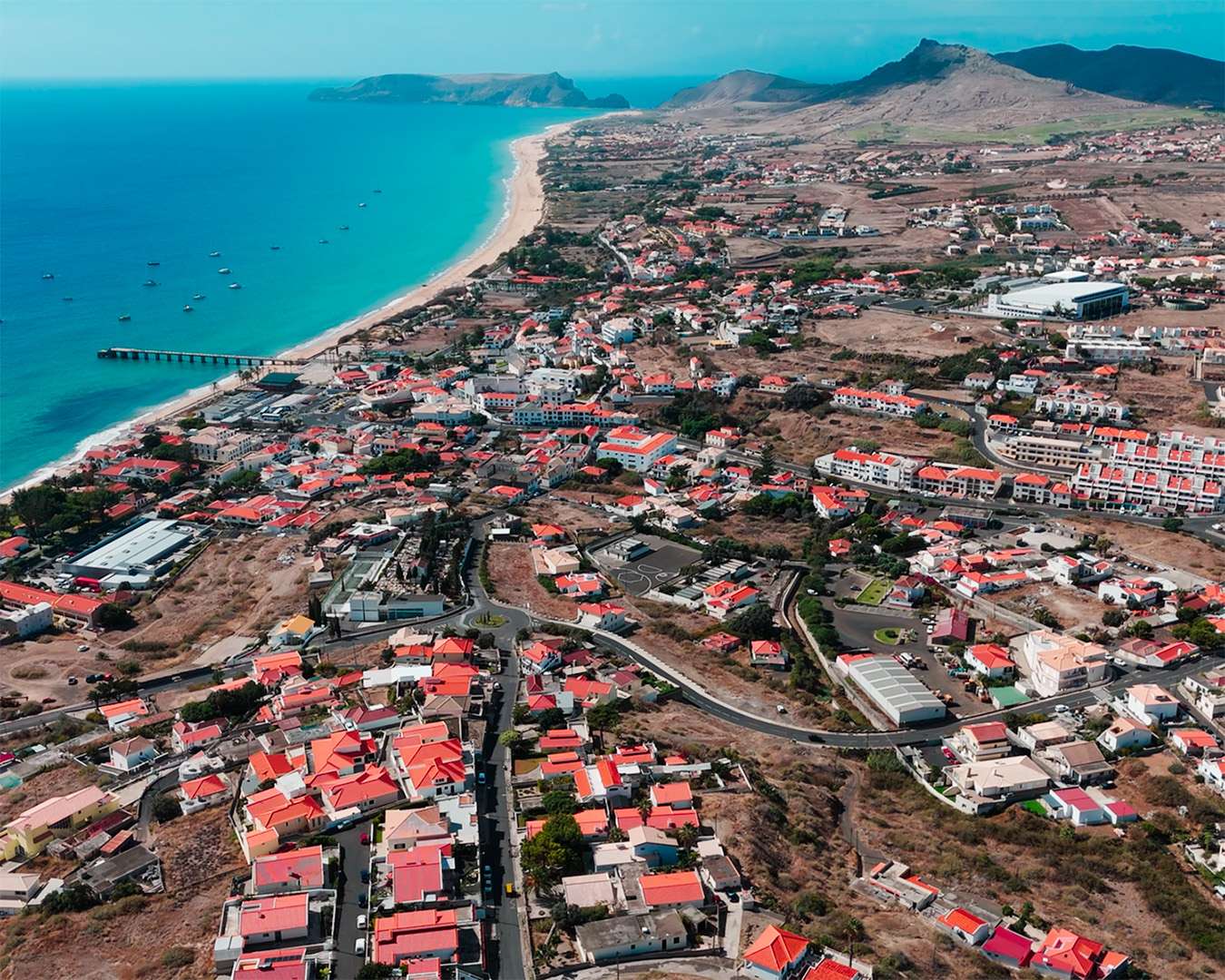 Vila Baleira von oben, rote Dächer vor dem langen hellen Strand und der Pier in der Bucht