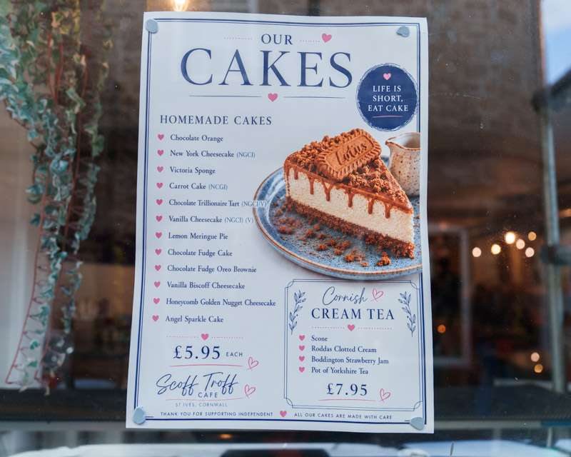 Cafe window card in St Ives listing homemade cakes and a Cornish cream tea