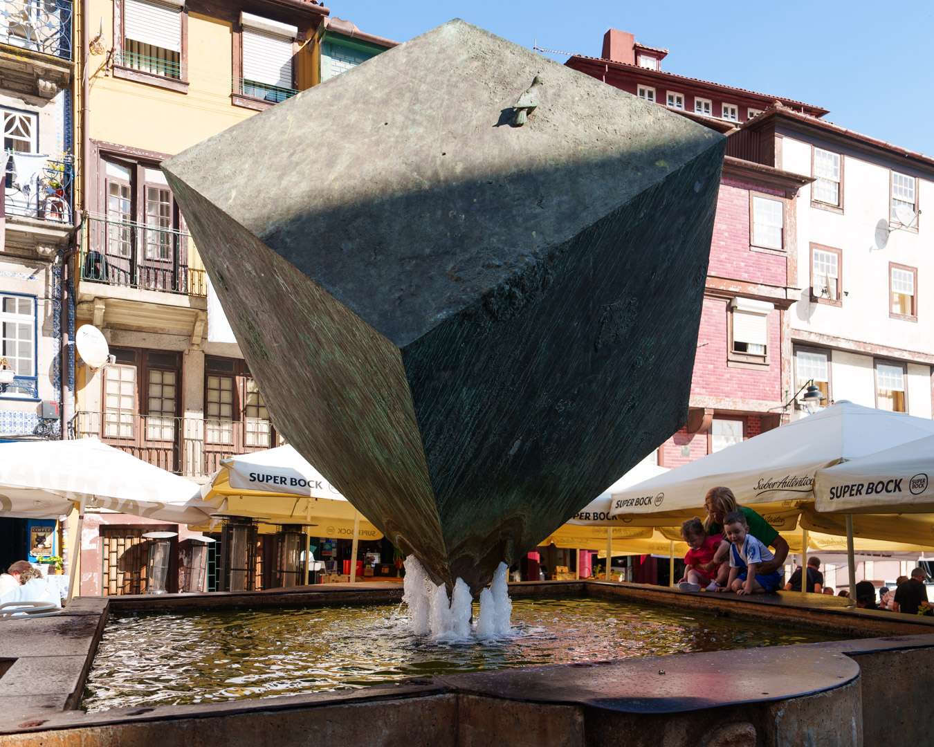 Bronzener W&uuml;rfel auf der Spitze in einem Brunnen auf der Pra&ccedil;a da Ribeira in Porto