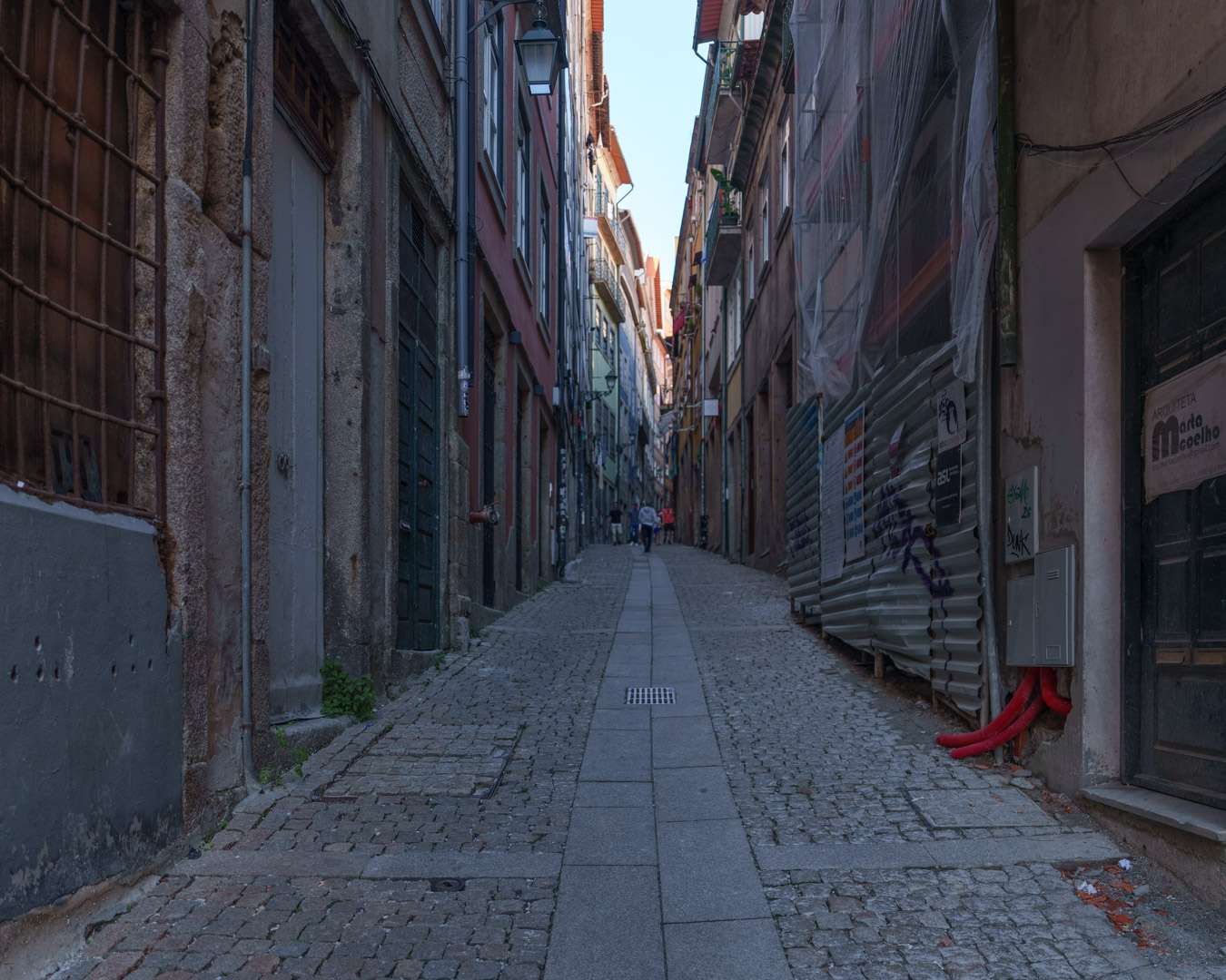 Leere gepflasterte Gasse in der Altstadt von Porto zwischen hohen Hausw&auml;nden