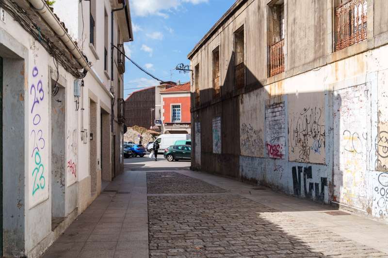 Empty lane of abandoned houses with graffiti in an older quarter of Vilagarcía de Arousa