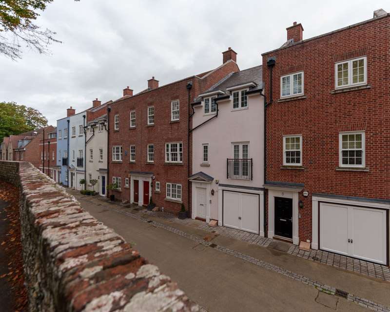 The Roman city wall of Chichester with brick houses built along the top of the rampart