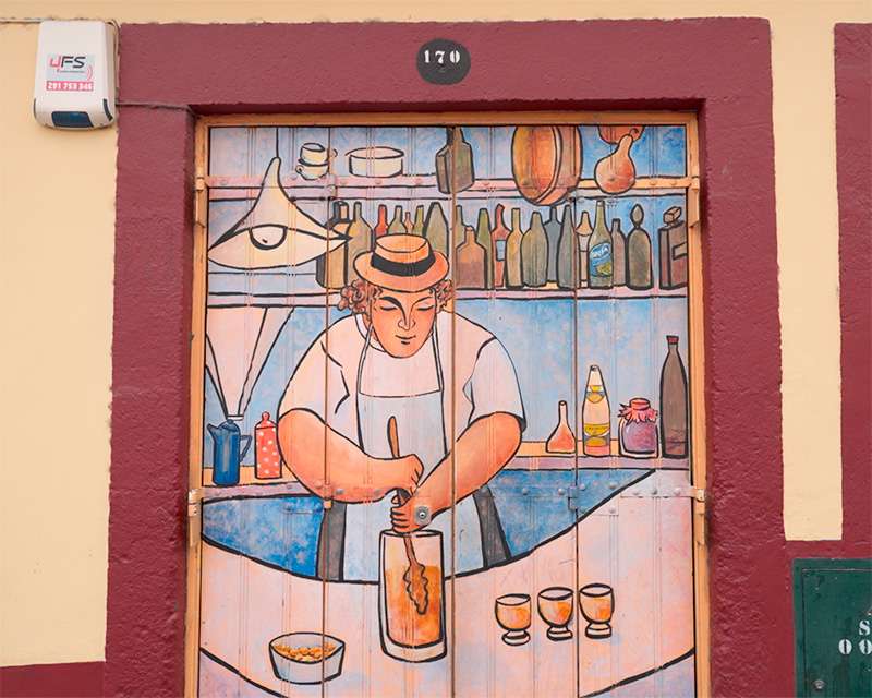 Painted door number 170 on Rua de Santa Maria showing a Madeira wine bar scene