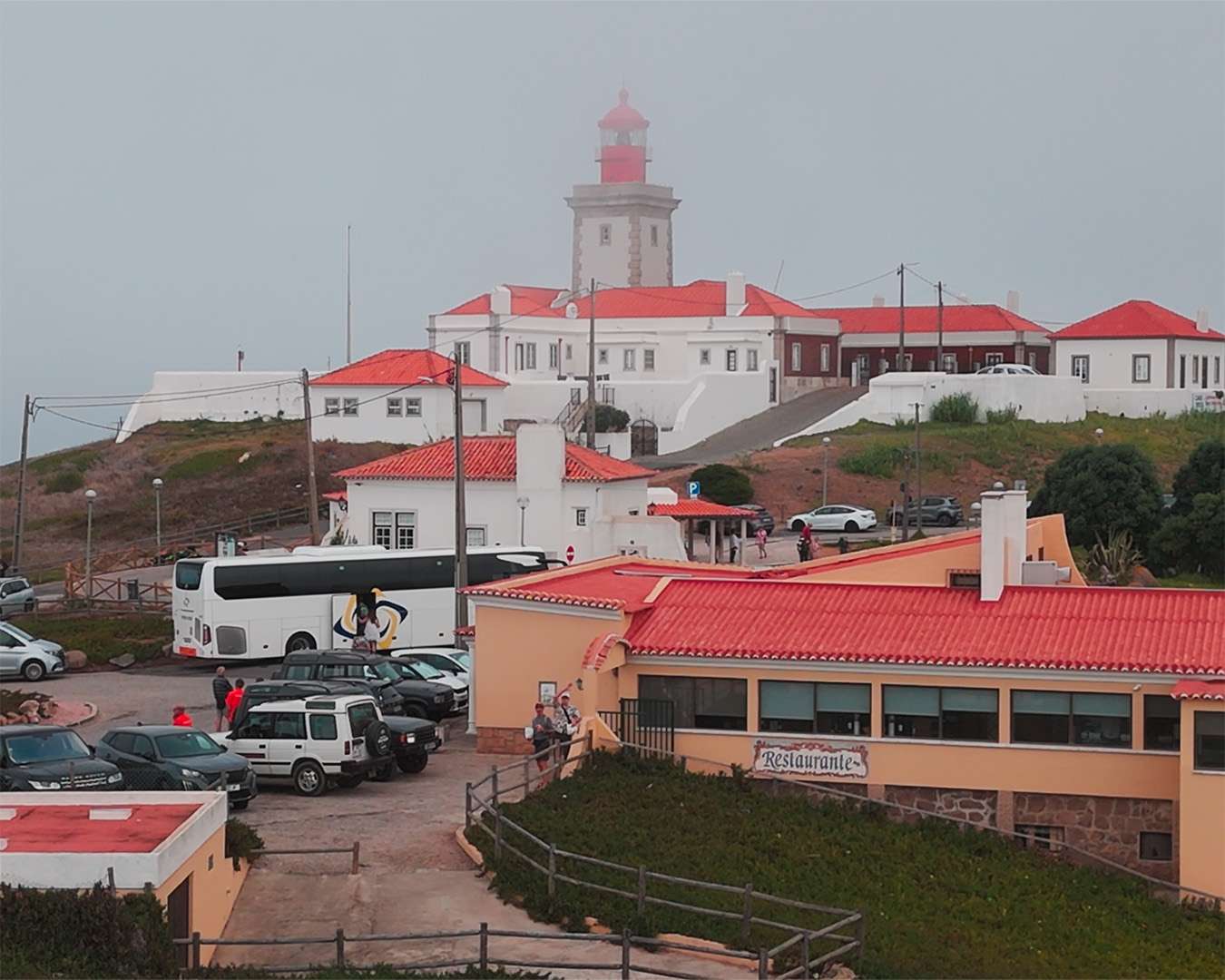 Busse und Autos auf dem Parkplatz unterhalb der Leuchtturmgebäude am Cabo da Roca