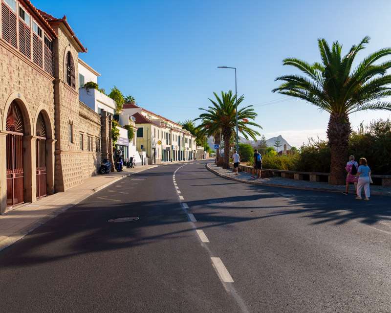 Hauptstraße von Vila Baleira in der Mittagssonne mit Palmen und einem Steingebäude