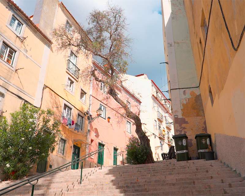 Treppengasse zwischen hellen Hausfronten in der Alfama, Lissabon