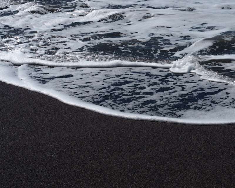 Brandung über dem schwarzen Vulkansand von Puerto de Tazacorte