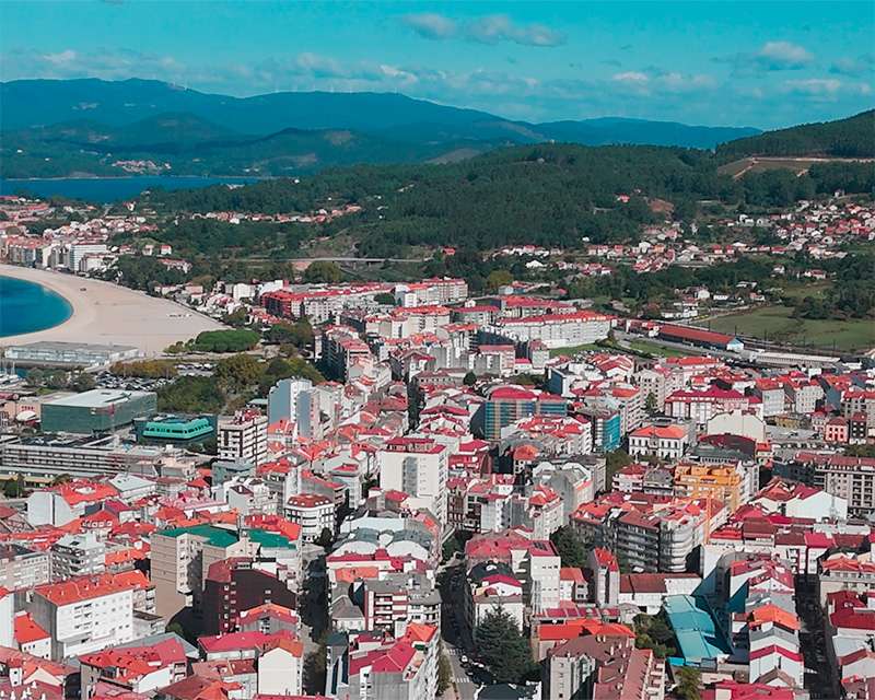 Aerial view across the rooftops of Vilagarcía de Arousa towards the beach and the Barbanza hills