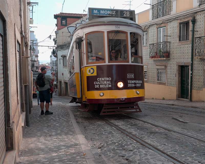 Die Straßenbahn 28 kommt eine schmale Gasse der Alfama herunter, Lissabon
