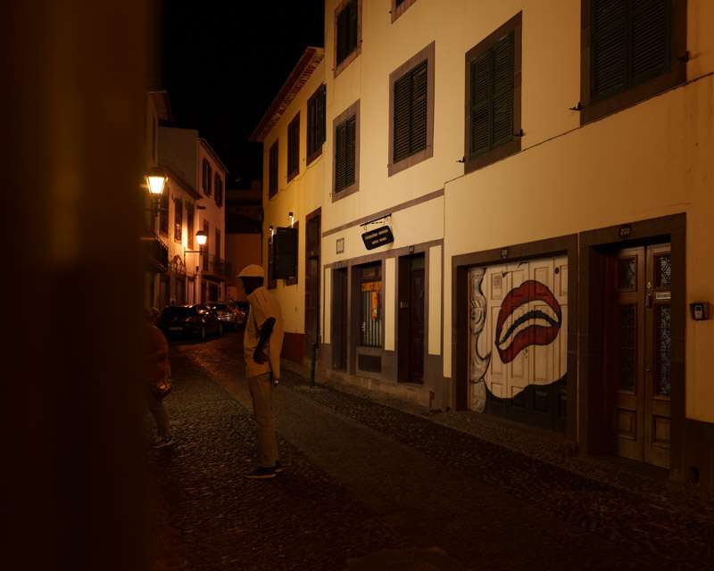 Dark side street in Funchal's Zona Velha with closed shutters at night