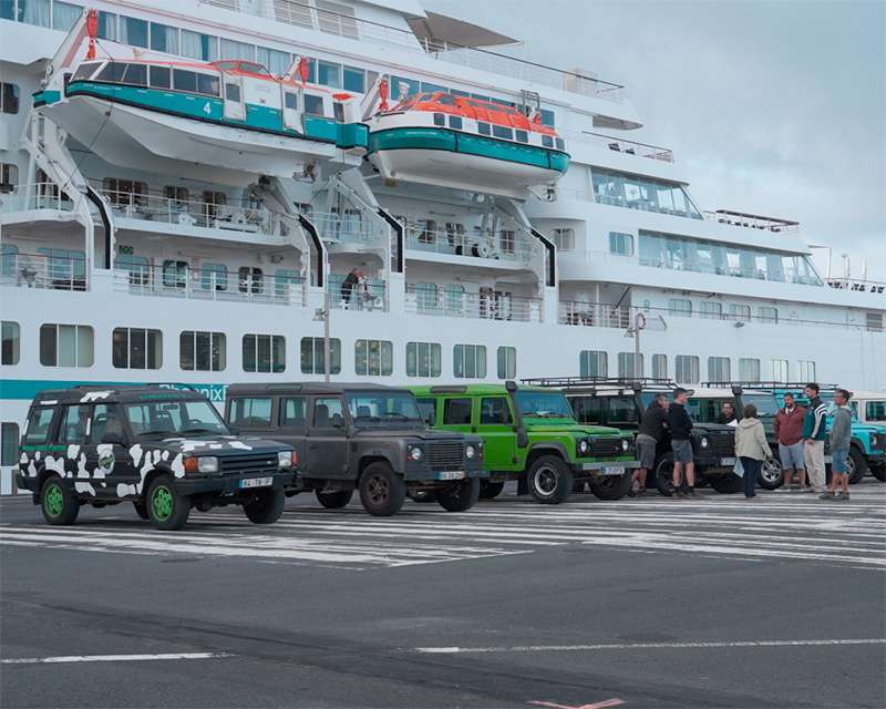 Land Rovers lined up on the quay beside a cruise ship at Ponta Delgada